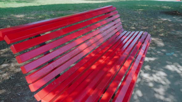 Brightly Painted Red Bench Stands in City Park in Burano