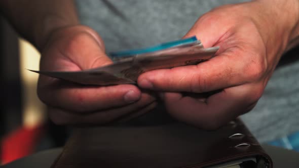 Close-up. The guy counts the rest of the money. Holds banknotes. Financial crisis