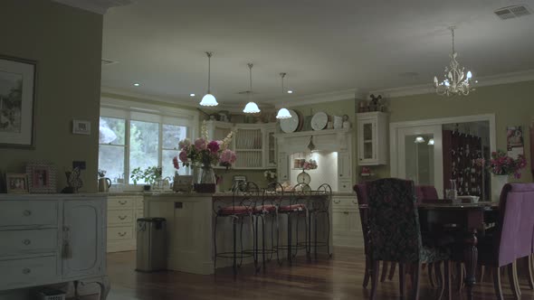 Wide tracking shot of country styled kitchen with fresh flowers on an autumn afternoon.