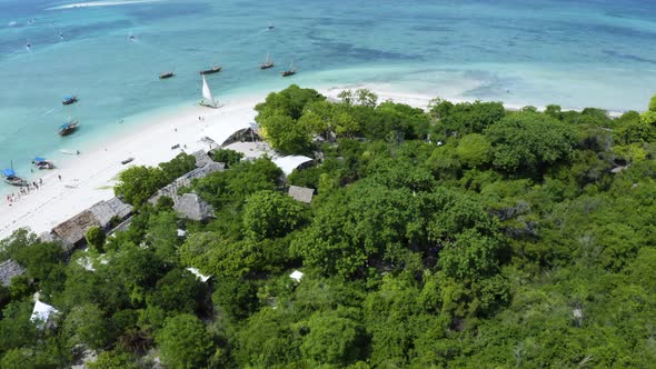 Fishing village with anchored boats on Zanzibar coast, drone shot.