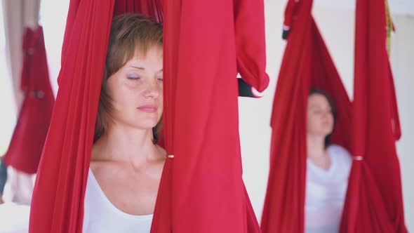 Pretty Lady Sits in Red Hammock and Practices Meditation