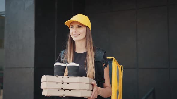 Woman Giving a Fast Food Order on the Background of a Modern Building Near the