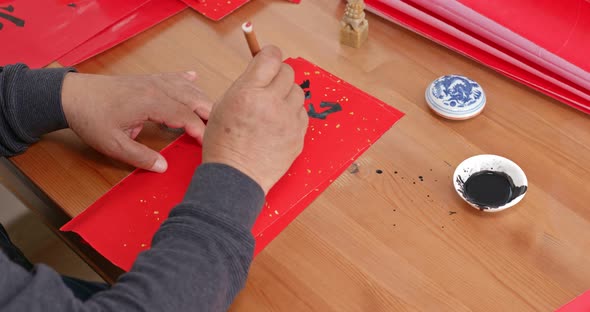 Man write chinese calligraphy for lunar new year