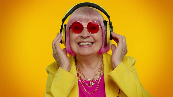 Senior Woman Listening Music on Headphones Dancing Disco Fooling Having Fun Gesticulating Hands