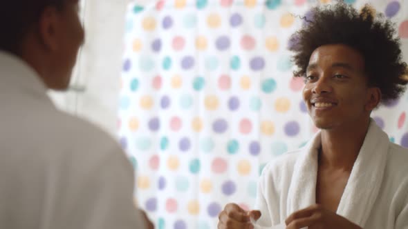 Handsome African Man Removing Bio-cellulose Sheet Mask From Face