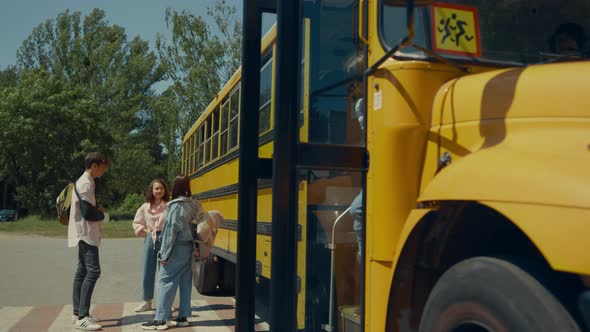 Two Classmates Leaving School Bus Open Door