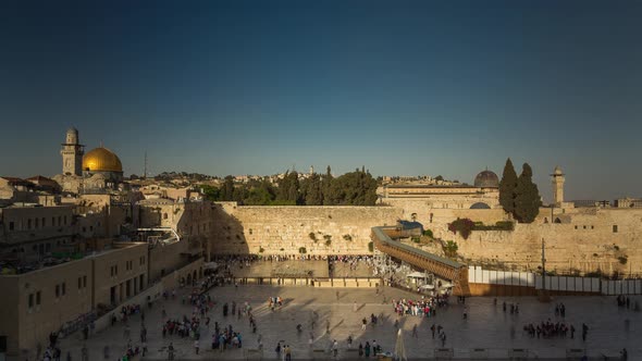 People on a beautiful evening pray near the Western Wall in Jerusalem, Israel