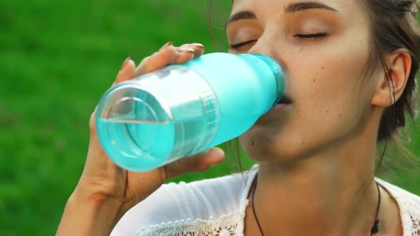 Beautiful Young Girl Is Drinking Water While Doing Yoga