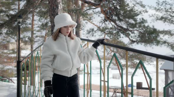 Happy Young Girl Walking on Footbridge in Winter Park