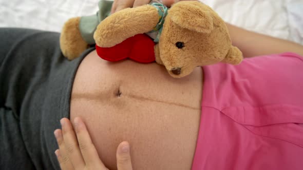 Happy Pregnant Woman Sleeping on Bed in Bedroom