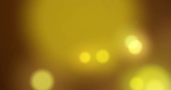 Animation of yellow glowing spots of light moving in hypnotic motion on black background