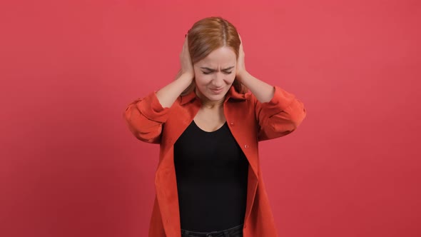 Close Up of a Confused Woman Holding Her Hands To Her Ears and Nodding