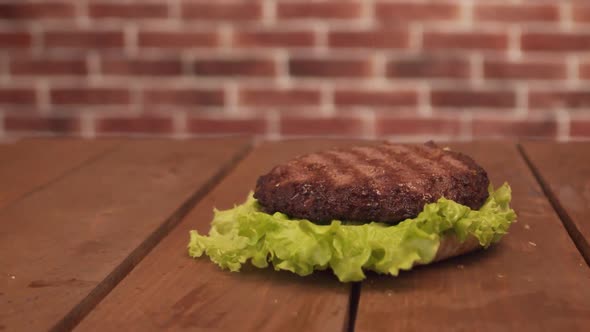 Delicious Burger with Ingredients Falls on Toasted Bun Against Background of Brick Wall. Burger