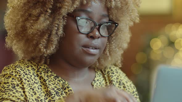 Young Black Woman Using Laptop in Cafe