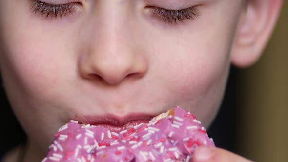 Portrait of a caucasian boy eating a donut.Children love sweet and donuts.