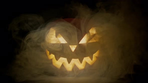 Halloween Pumpkin with Smoke Around It. Glowing Pumpkin on Dark Background.