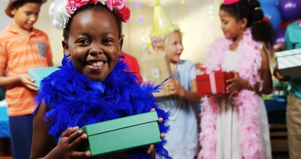 Girl holding a gift box during birthday party at home 4k