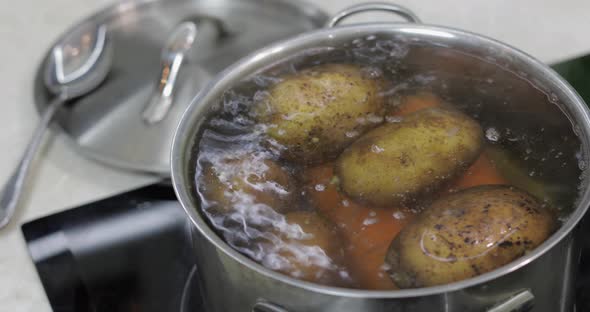 Hot Boiling Pan with Vegetables Potatoes and Carrots. Cooking in Kitchen