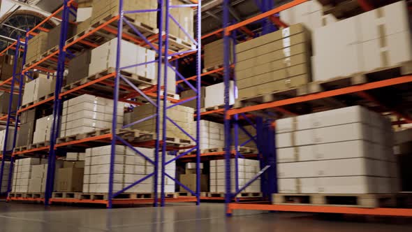 Pallets with boxes on the shelves in the large industrial loft warehouse.