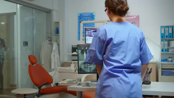 Stomatological Nurse Inviting Patient in Dental Room