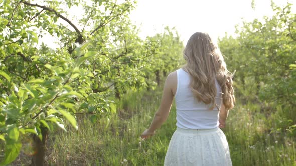 Joyful Active Woman Walking Through Apple Orchard