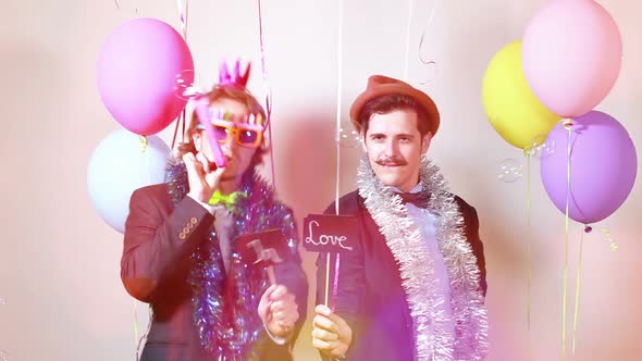 Slow motion of two men holding boards in love in photo booth