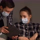 Man and Woman in Masks with a Tablet - VideoHive Item for Sale