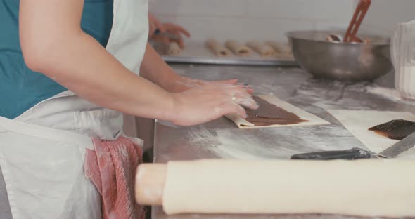 Bakers preparing a Plum jam filled Strudel in a bakery