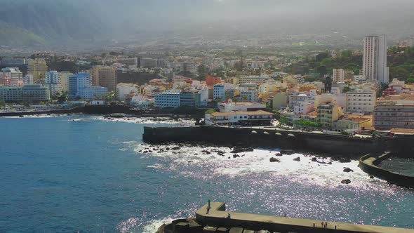 The vibrant city of Puerto de la Cruz, Tenerife, Canary Islands, and its harbor with stone piers, ro