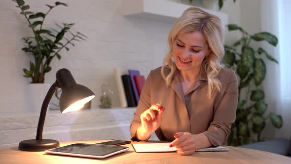 Positive Caucasian Woman Taking Pen and Writing Down Business Plan