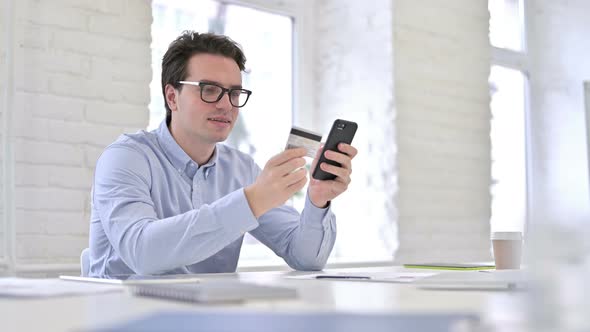 Working Young Man Celebrating Online Payment on Smartphone