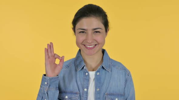 Indian Woman with OK Sign, Yellow Background 