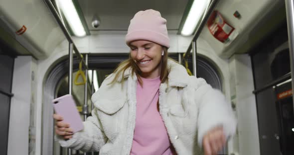 Crop View of Young Woman in Pink Hat Dancing While Listening To Music in Wireless Headphones