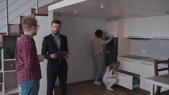 Real Estate Agent Talking with Owner While His Daughter and Wife