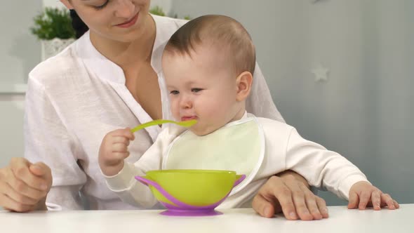 Baby with Bowl and Spoon Try To Eating