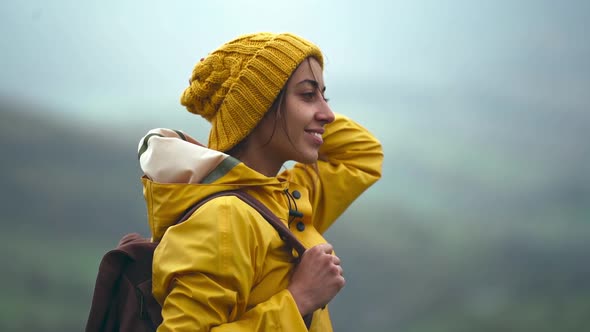 Slow Motion Side View Broll Tourist Woman in Yellow Wear Standing on Meadow with Beautiful Mountains