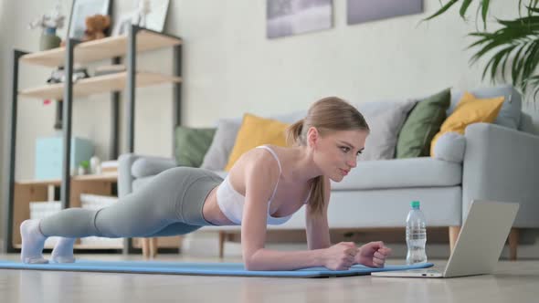 Beautiful Young Woman Doing Plank on Yoga Mat at Home