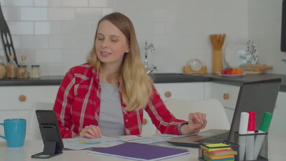 Pretty Female Freelancer Talking on Video Call on Phone and Discussing Startup