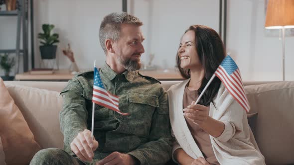 Army Officer and his Wife Waving American Flags alt