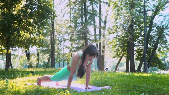 Meditating Outdoors Beautiful Young Yogi Woman Enjoying Relaxing on a Green Meadow in Sunny Weather