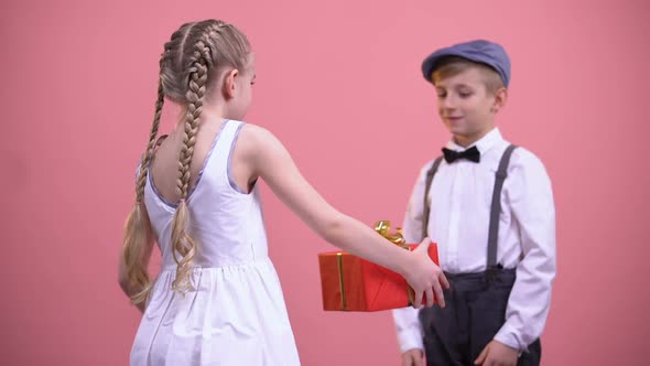 Little Girl in White Dress Giving Wrapped Present to Boyfriend, Valentines Day