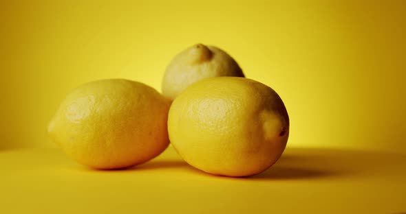 Rotating Fresh Lemons on a Yellow Background