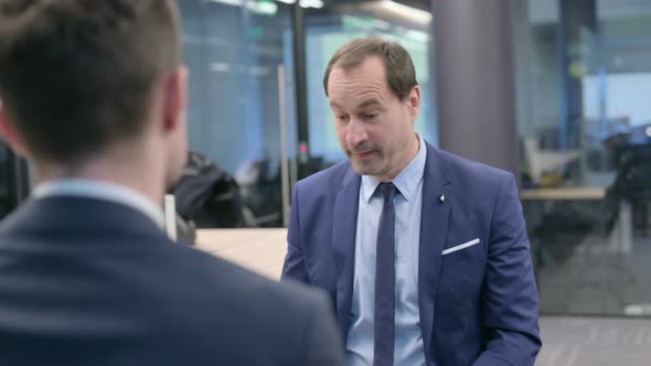 Rear View of Businessman Talking to Colleague