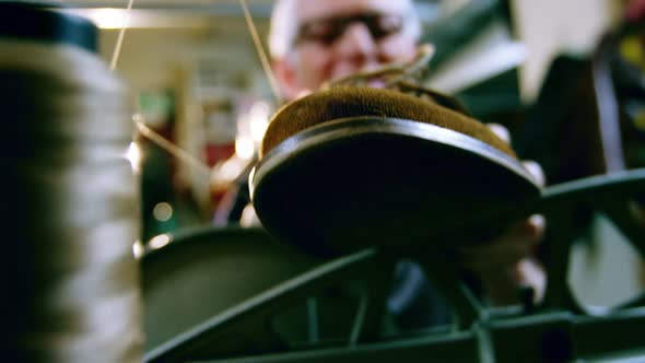 Shoemaker examining a shoe