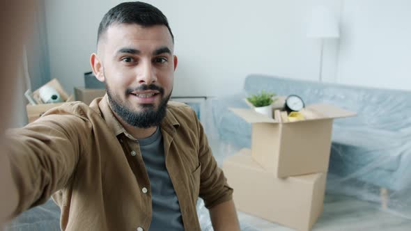 POV of Arab Man Making Online Video Call Talking and Showing House Key in New Apartment