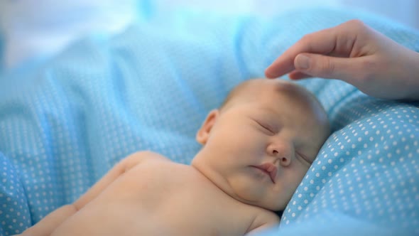 Mother's Hand Caring Her Sleeping Newborn Child