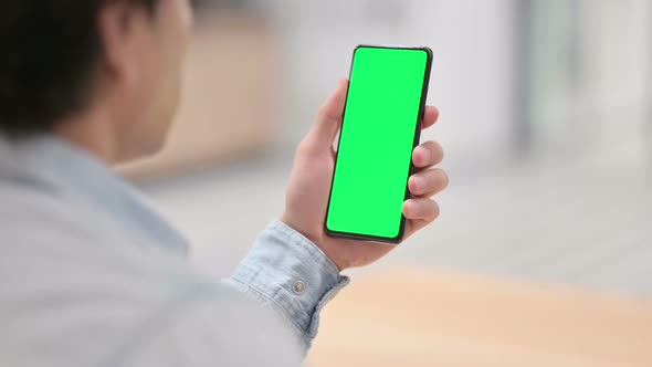 Rear View Man Using Smartphone with Green Chroma Key Screen