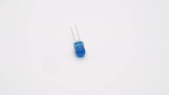 Blue LED Electronic Component Rotates on White Background Isolated