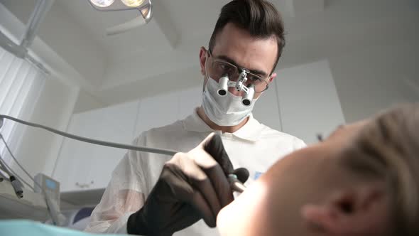 The dentist treats the patient's teeth. Young woman at the doctor's appointment