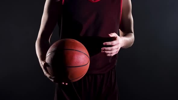 Young Basketball Player in a Dark Studio on a Black Background